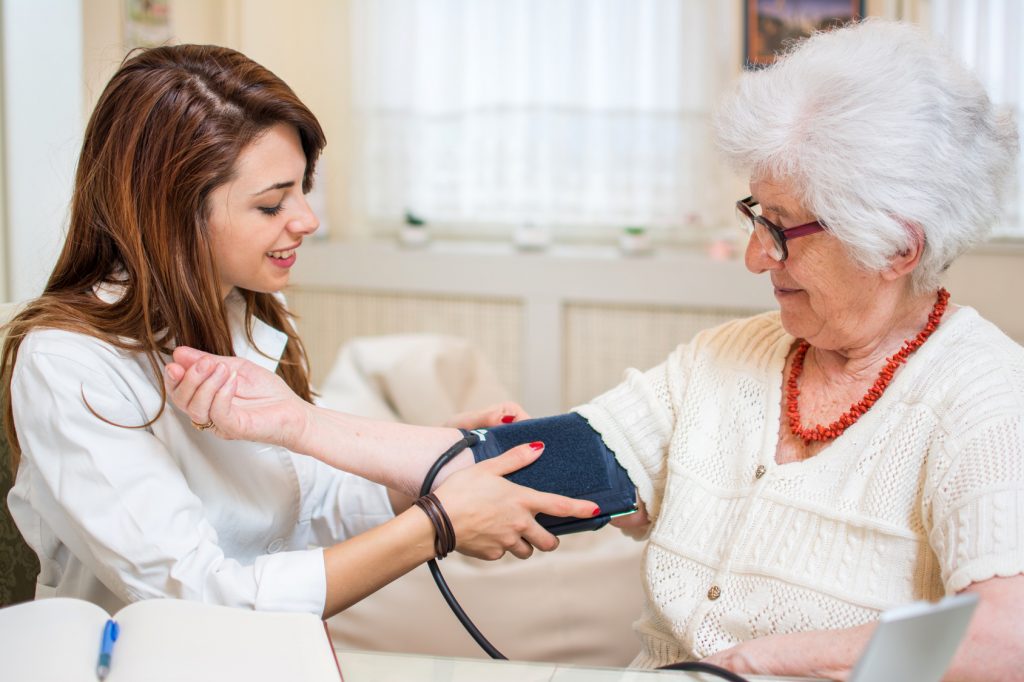 Kobieta, która mierzy ciśnienie tętnicze starszej osobie